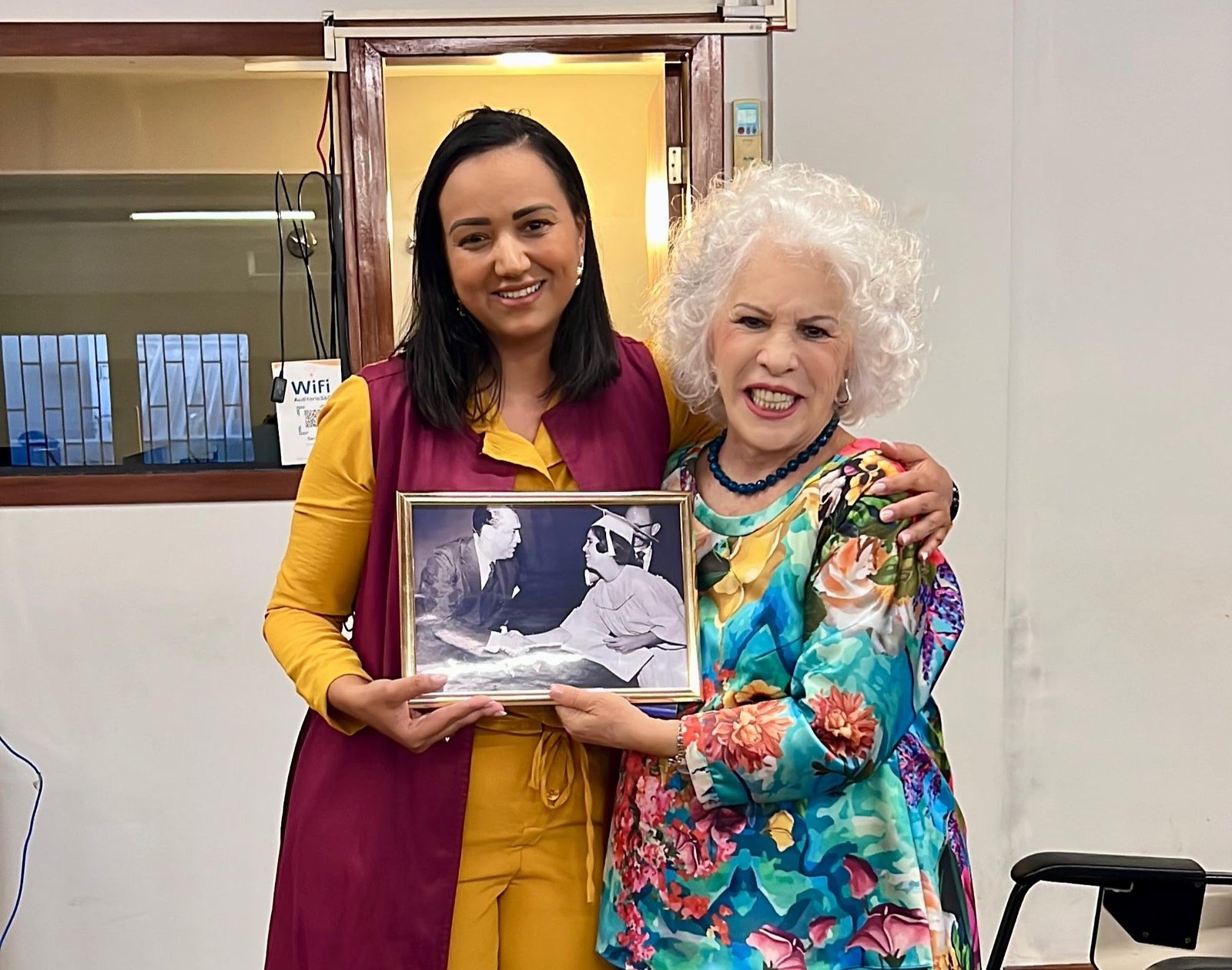 Paula Freitas e Cosete Ramos seguram fotografia histórica de Cosete com Juscelino Kubitschek